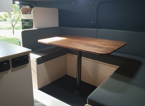 Aménagement intérieur dun van moderne avec coin repas minimaliste et table en bois.